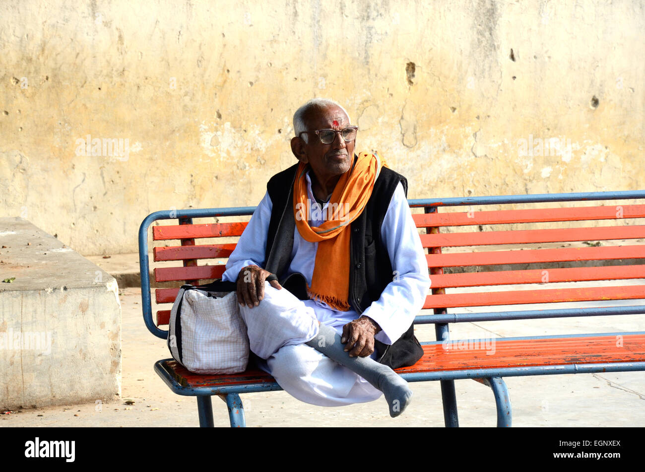 Un matrimonio indiano mantra chanter seduta su una panchina in una stazione ferroviaria del Madhya Pradesh India Foto Stock