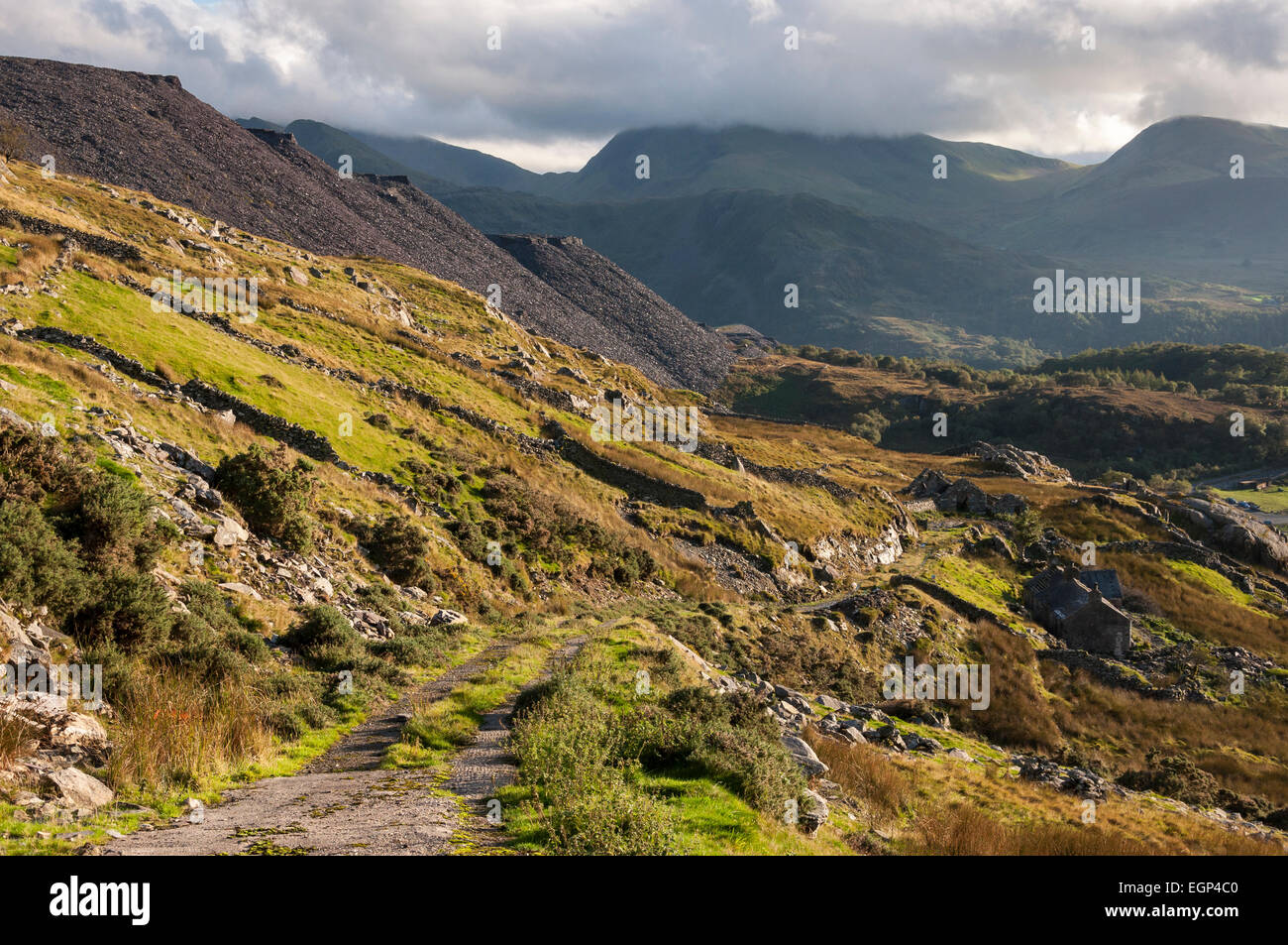 Resti di abitazioni al di sotto di Dinorwig cava di ardesia vicino a Llanberis nel Galles del Nord. Visualizza in basso una traccia approssimativa verso le montagne. Foto Stock