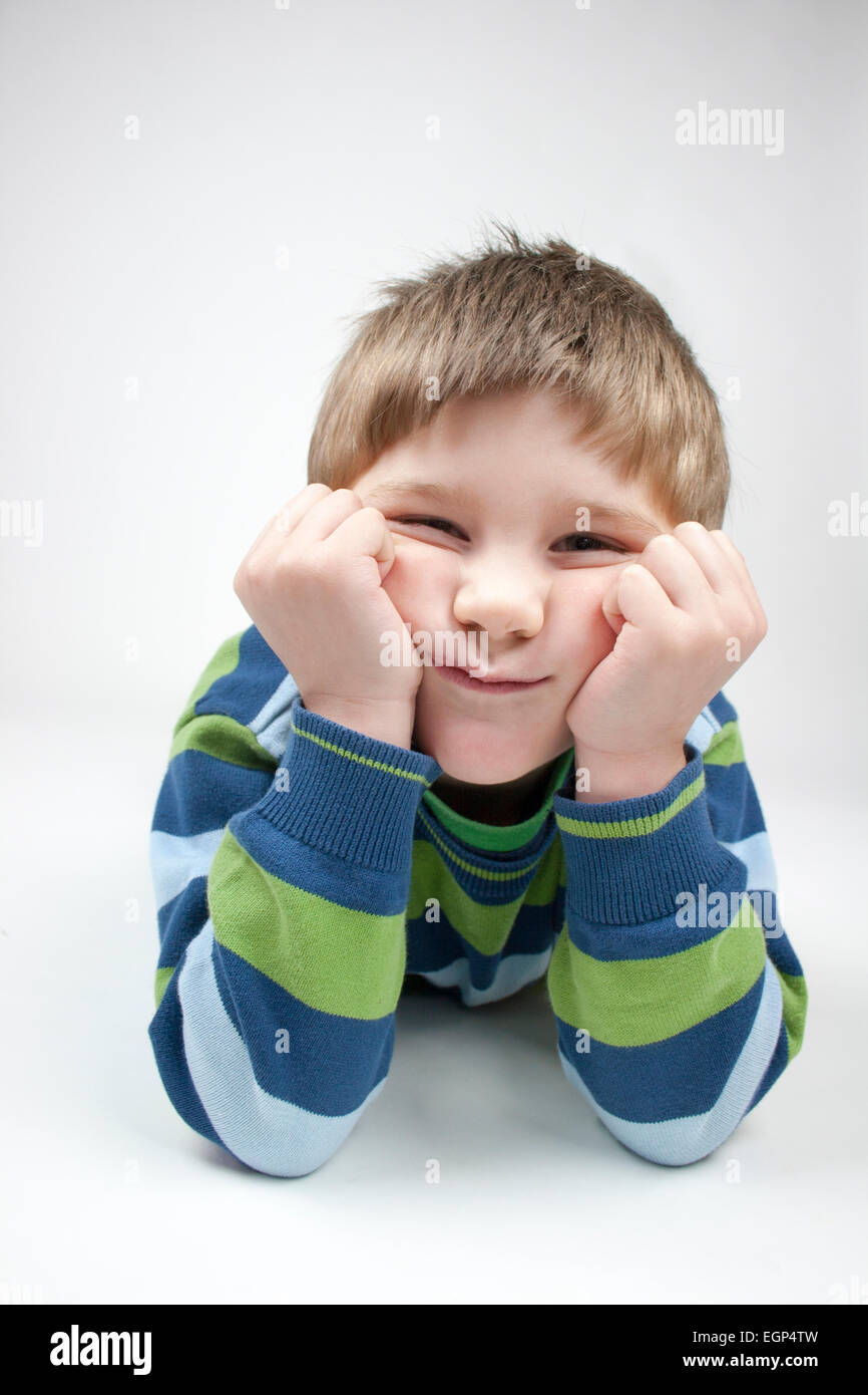 5 anno vecchio ragazzo che stabilisce la faccia schiacciata in testa le mani Foto Stock