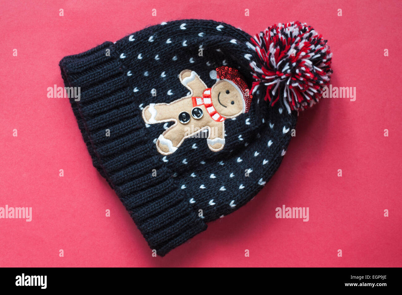 In bianco e nero con cappello di Gingerbread Man sul carattere e pompom isolato su sfondo rosso Foto Stock