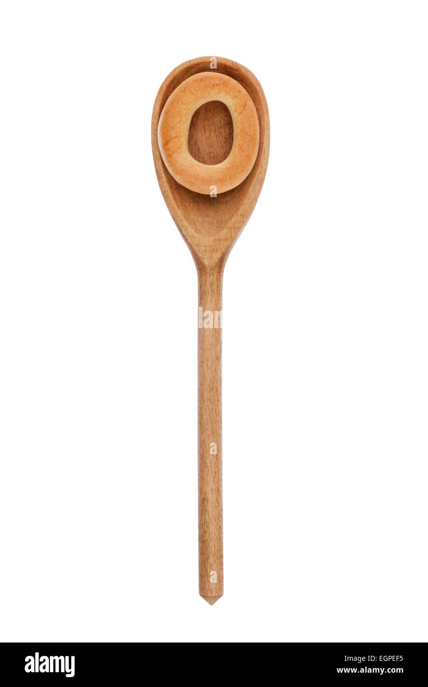 Il cucchiaio di legno con un bagel isolati su sfondo bianco Foto Stock