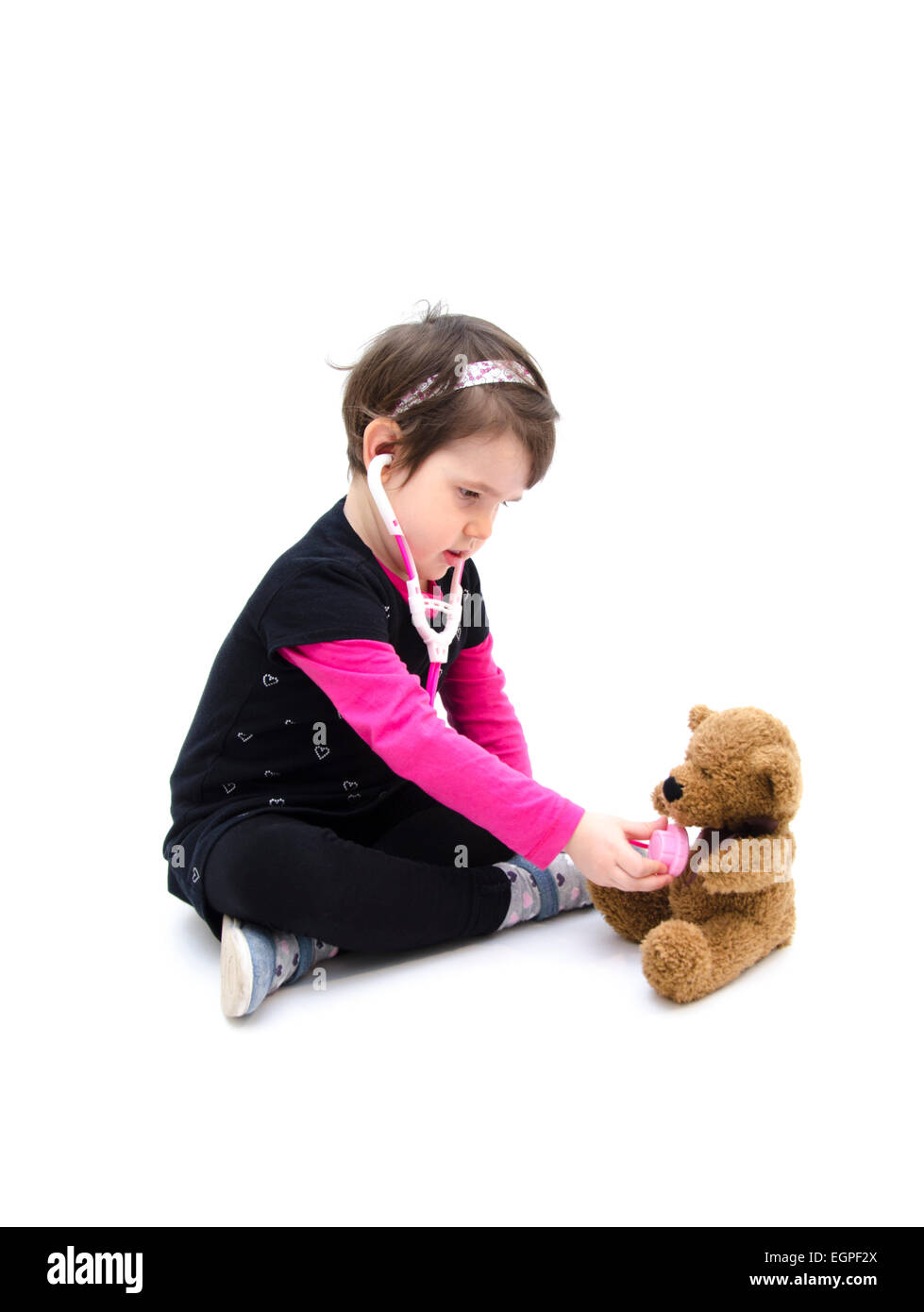 Piccola ragazza medico gioca con Teddy bear isolati su sfondo bianco Foto Stock