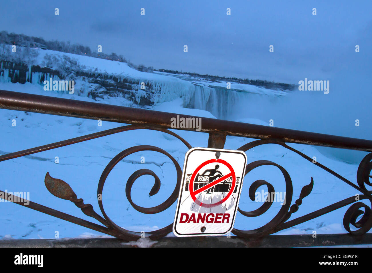 Segno di avvertimento del pericolo di cadere dalla staccionata lungo il fiume Niagara a ferro di cavallo congelate cade in inverno mattina Foto Stock