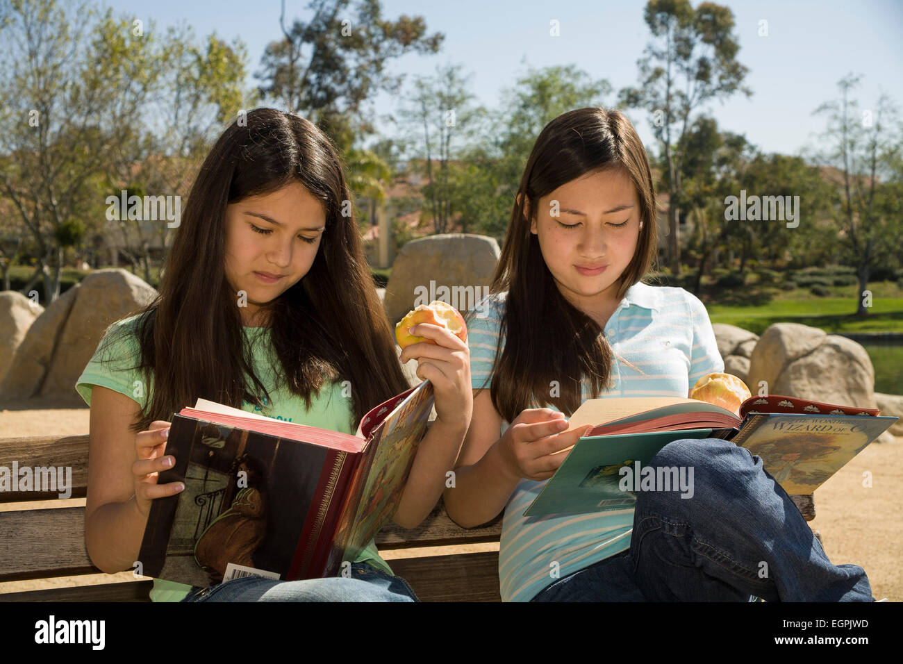 Giovane gente Tween appendere fuori Vietnamese-Caucasian adolescenti messicani ispanica due ragazze di 12-13 anni leggere libri di lettura insieme signor © Myrleen Pearson Foto Stock