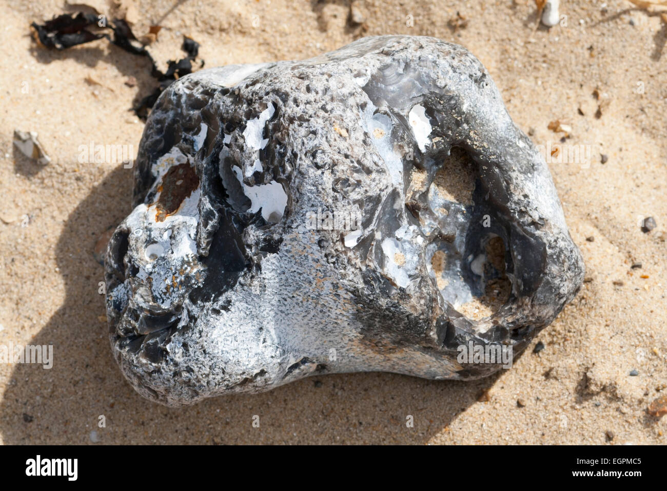 Rock Flint su di una spiaggia di sabbia in Norfolk Foto Stock