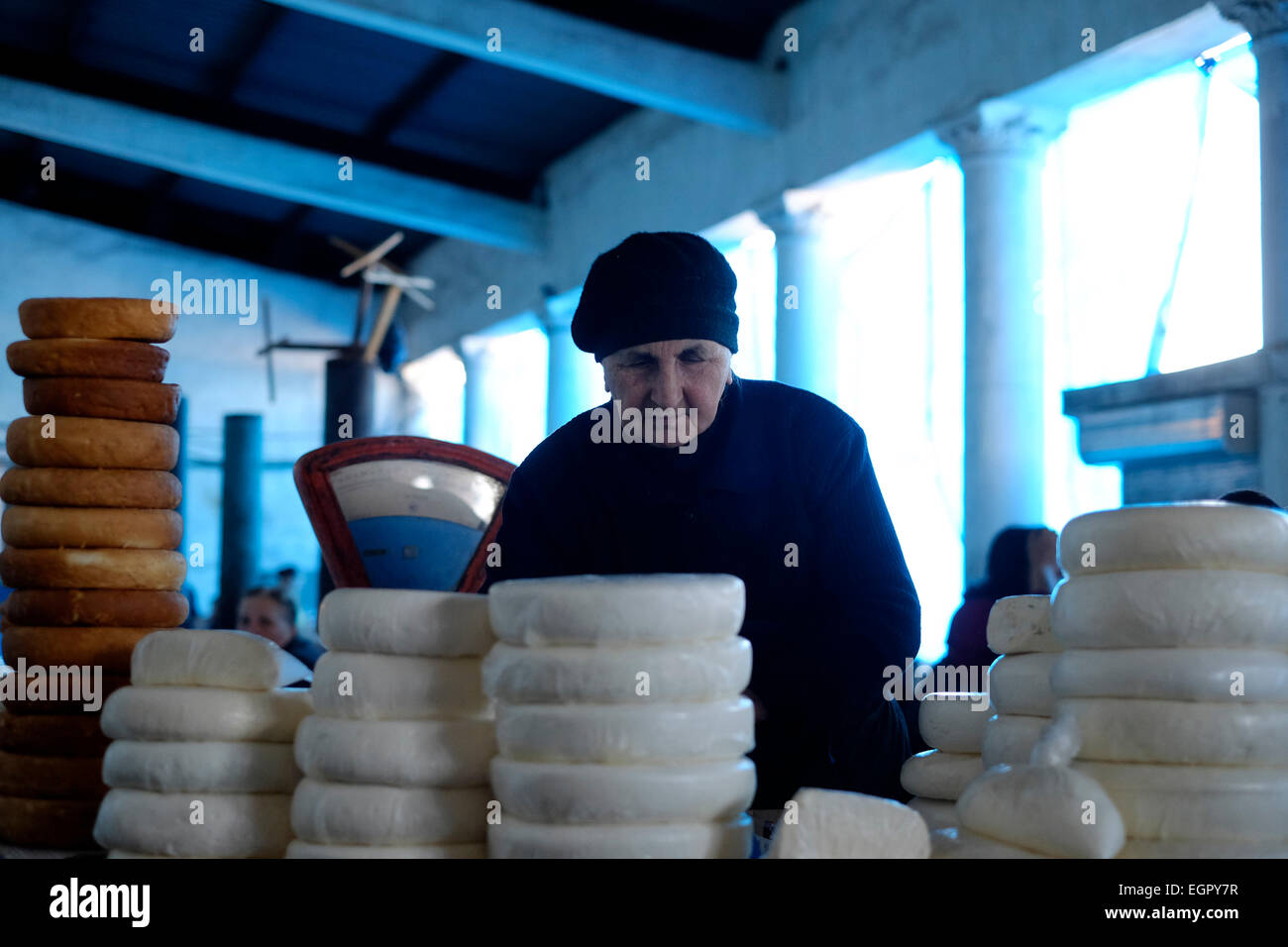 Un venditore vende ruote di formaggio sulguni al mercato nella città di Zugdidi, la capitale della regione Samegrello Zemo Svaneti nella Repubblica di Georgia Foto Stock