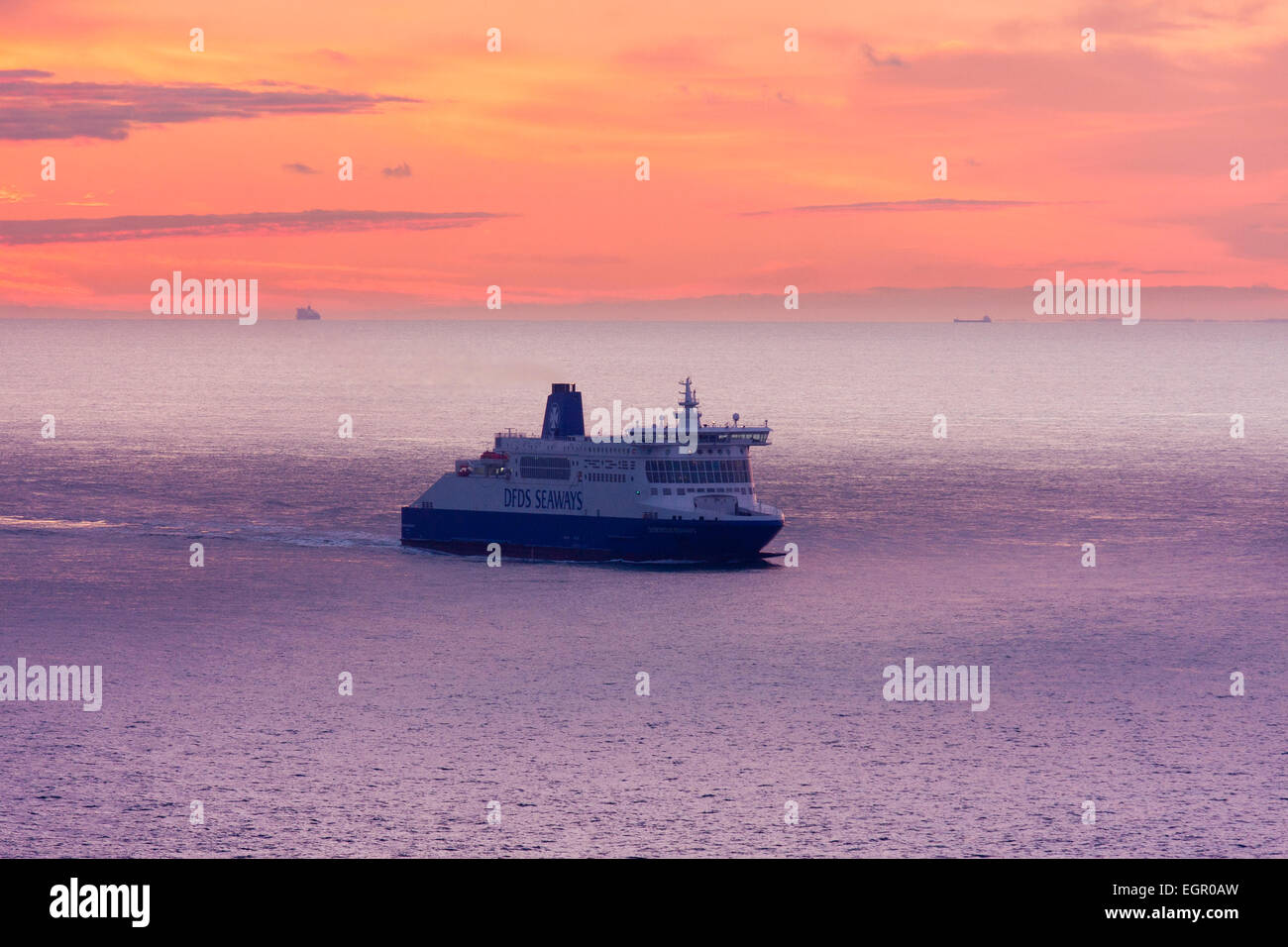 Dover. Traghetto in auto 'DDS Seaways' in mare che naviga attraverso la Manica all'alba con un cielo rosso e nuvole all'orizzonte sopra la costa francese. Foto Stock