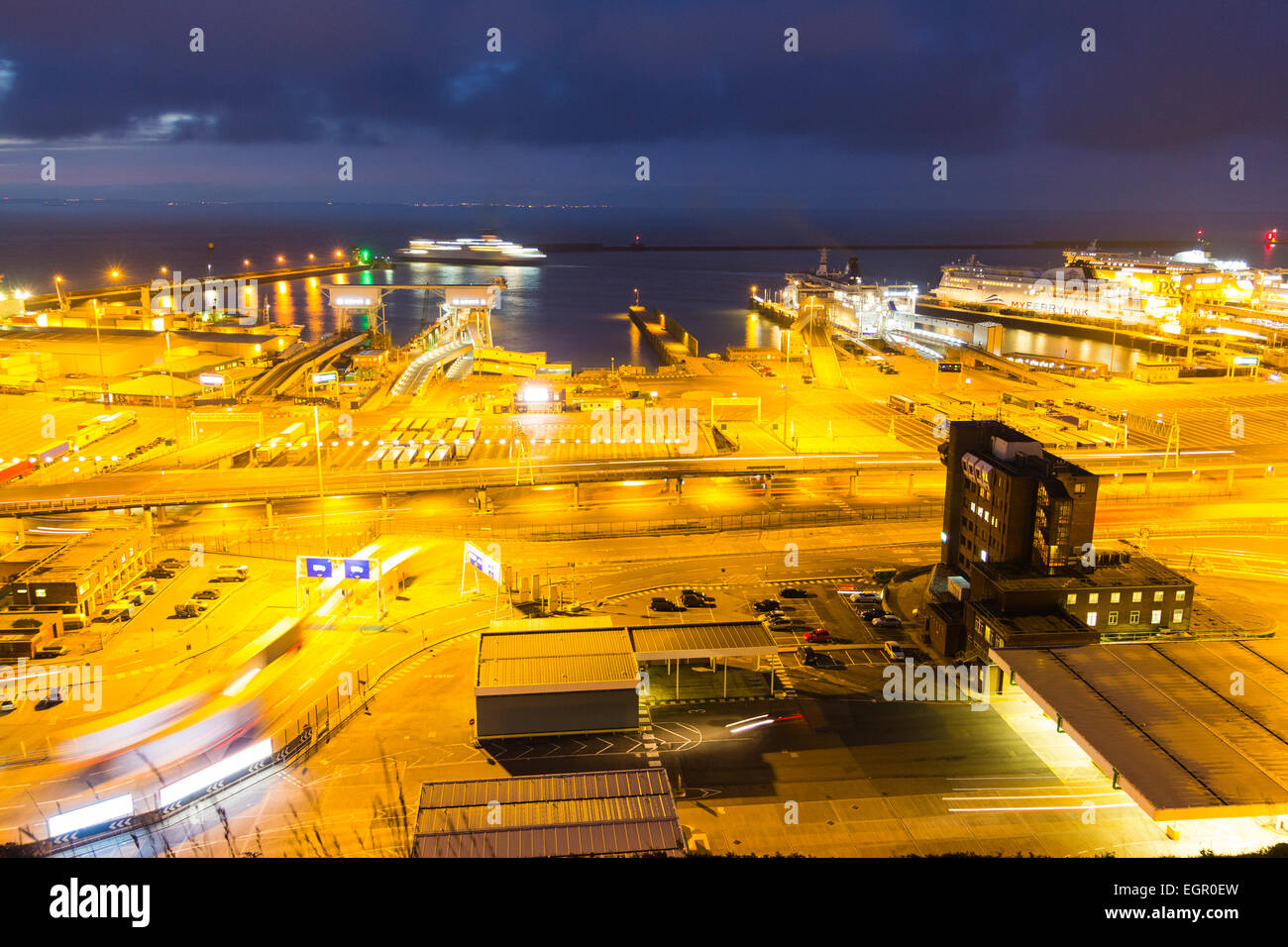 Scena notturna con l'alba che inizia al terminal dei traghetti illuminati presso il porto del canale inglese di dover. Vista ad alto angolo del porto. Foto Stock