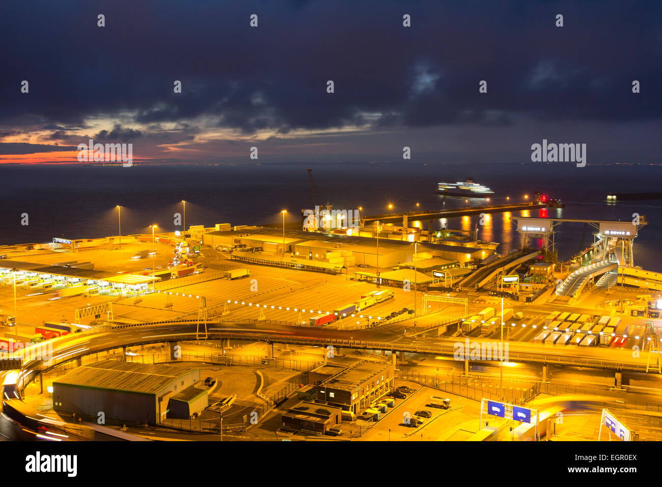 Scena notturna con l'alba che inizia al terminal dei traghetti illuminati presso il porto del canale inglese di dover. Vista ad alto angolo del porto. Foto Stock