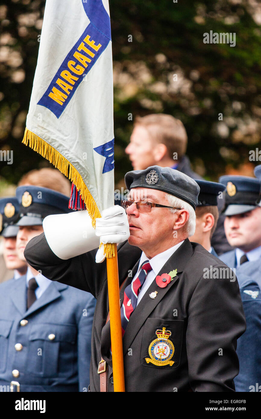 Veterano ex-serviceman, in piedi al livello di attenzione durante il servizio esterno della domenica di memoria. La bandiera è cucita con 'Margate'. Foto Stock