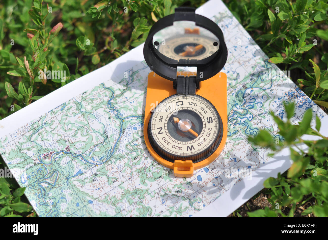 Bussola sulla mappa. Bussola magnetica in forma espansa è situato su una cartina topografica. Foto Stock