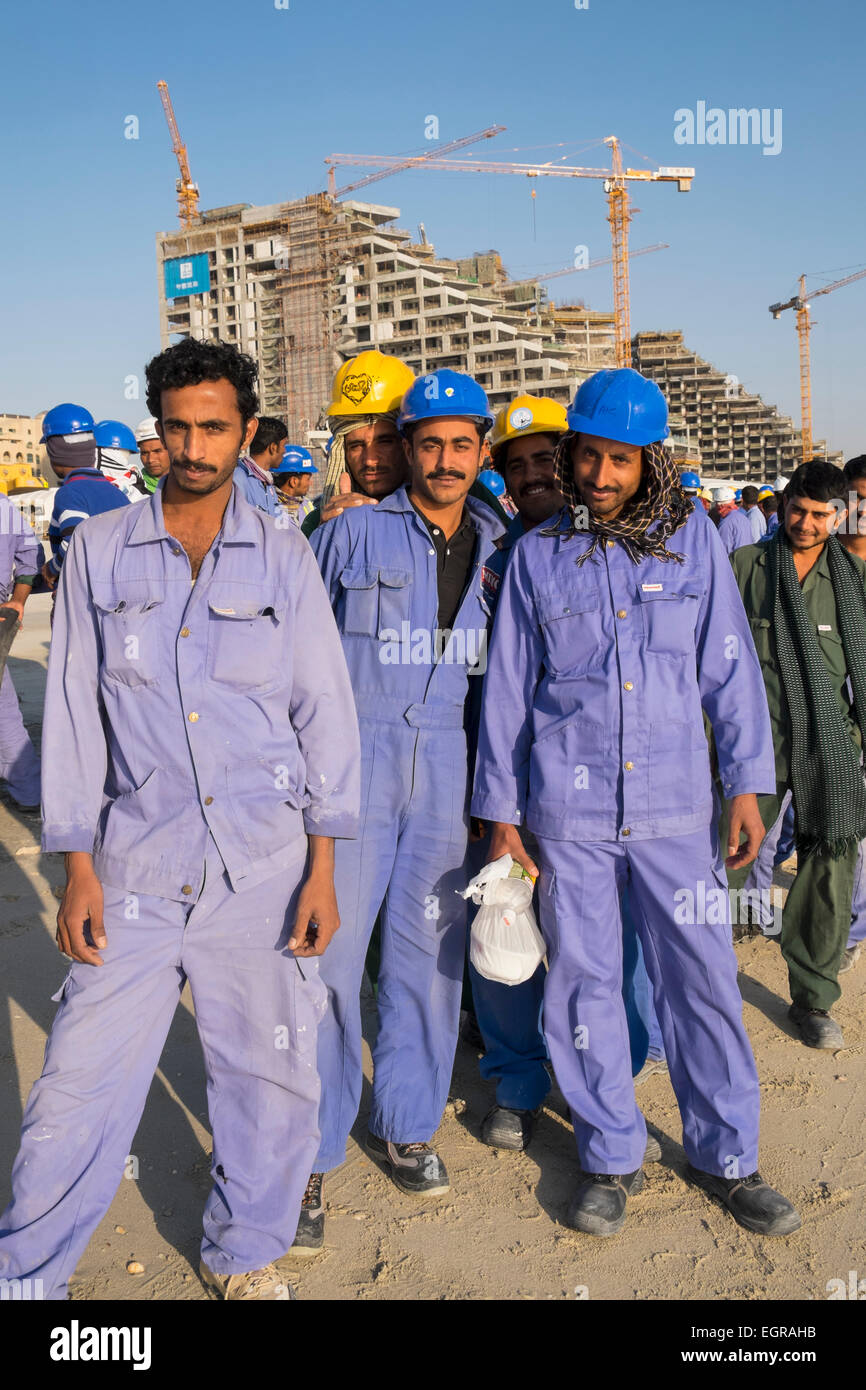 Lavoratori edili accodamento per salire su un autobus a quarti viventi al termine della giornata lavorativa in Dubai Emirati Arabi Uniti Foto Stock