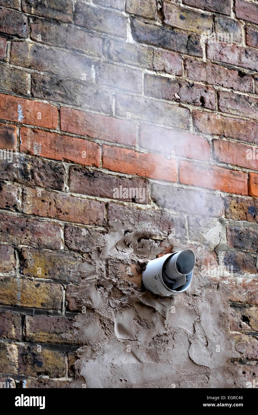 I fumi di scarico dalla caldaia a gas proveniente dal tubo nel muro di casa in un freddo giorno Foto Stock
