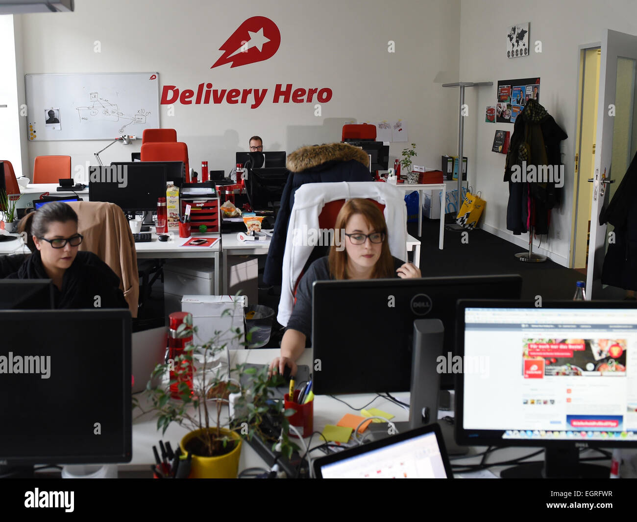 Berlino, Germania. 24 Febbraio, 2015. I membri dello staff lavorano sulla propria workstation in sede di ordine online e piattaforme di distribuzione "Lieferheld' e 'Delivery Hero" di Berlino, Germania, 24 febbraio 2015. Più di 7000 ristoranti sono elencati sul cibo online piattaforma delvery 'Lieferheld'. 'Delivery Hero' è leader del mercato mondiale per i prodotti alimentari online gli ordini di funzionamento plaforms simile in 24 paesi. Foto: Jens Kalaene/dpa/Alamy Live News Foto Stock