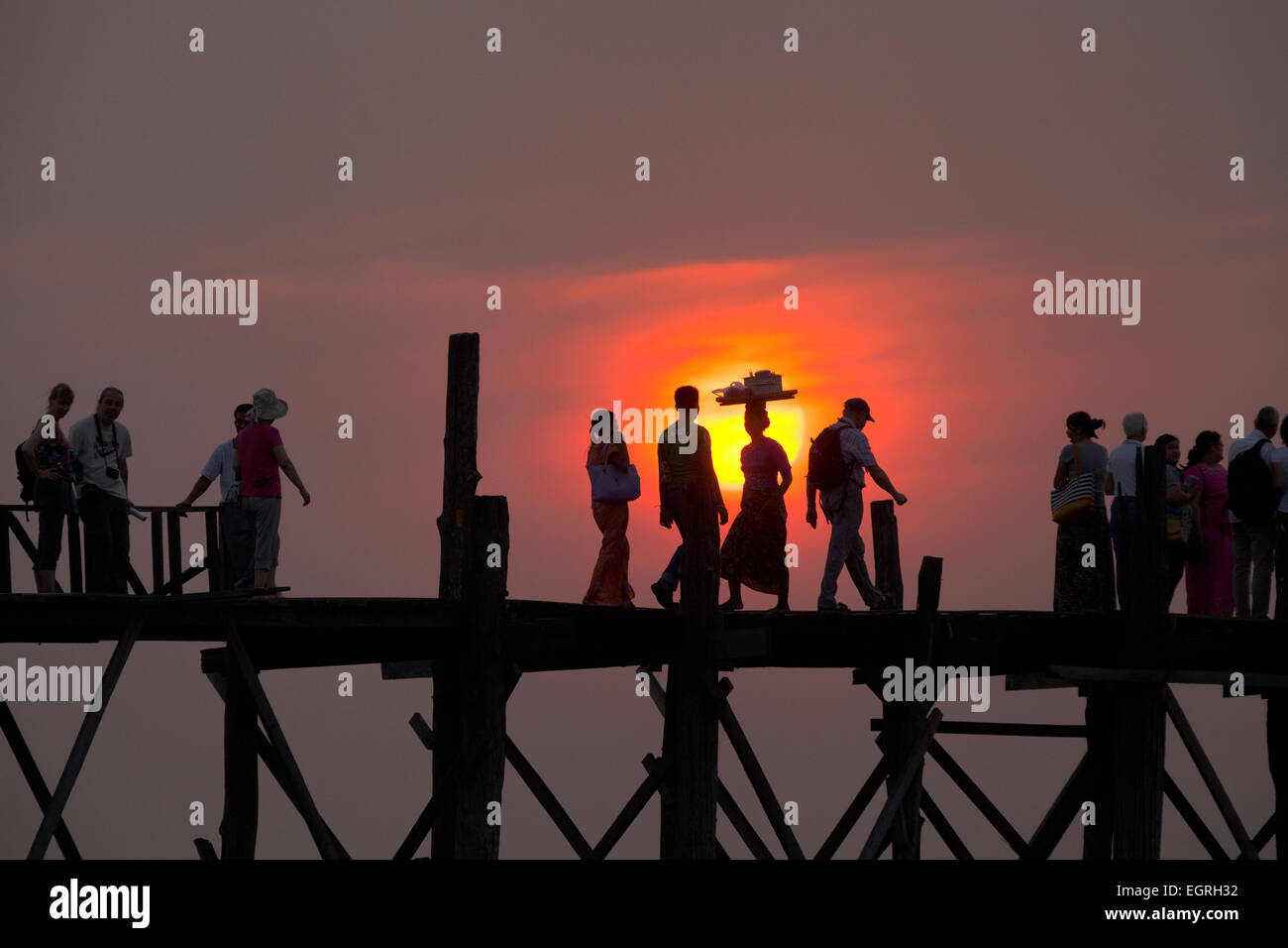 Le persone che attraversano la U Bein bridge al tramonto, Myanmar ( Birmania ), Asia Foto Stock