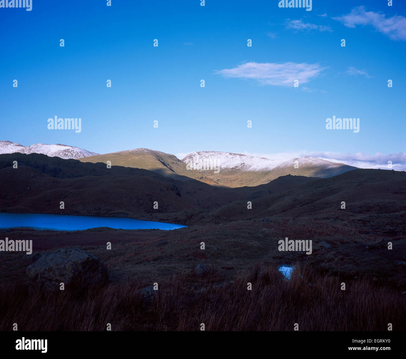 Cattura la luce del sole le innevate vette di Fairfield St Sunday Crag Helvellyn da Easedale Tarn sopra Grasmere Cumbria Foto Stock