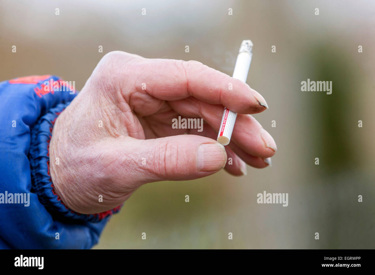 Mano fumatrice, un uomo anziano con una sigaretta, un uomo anziano da vicino Foto Stock