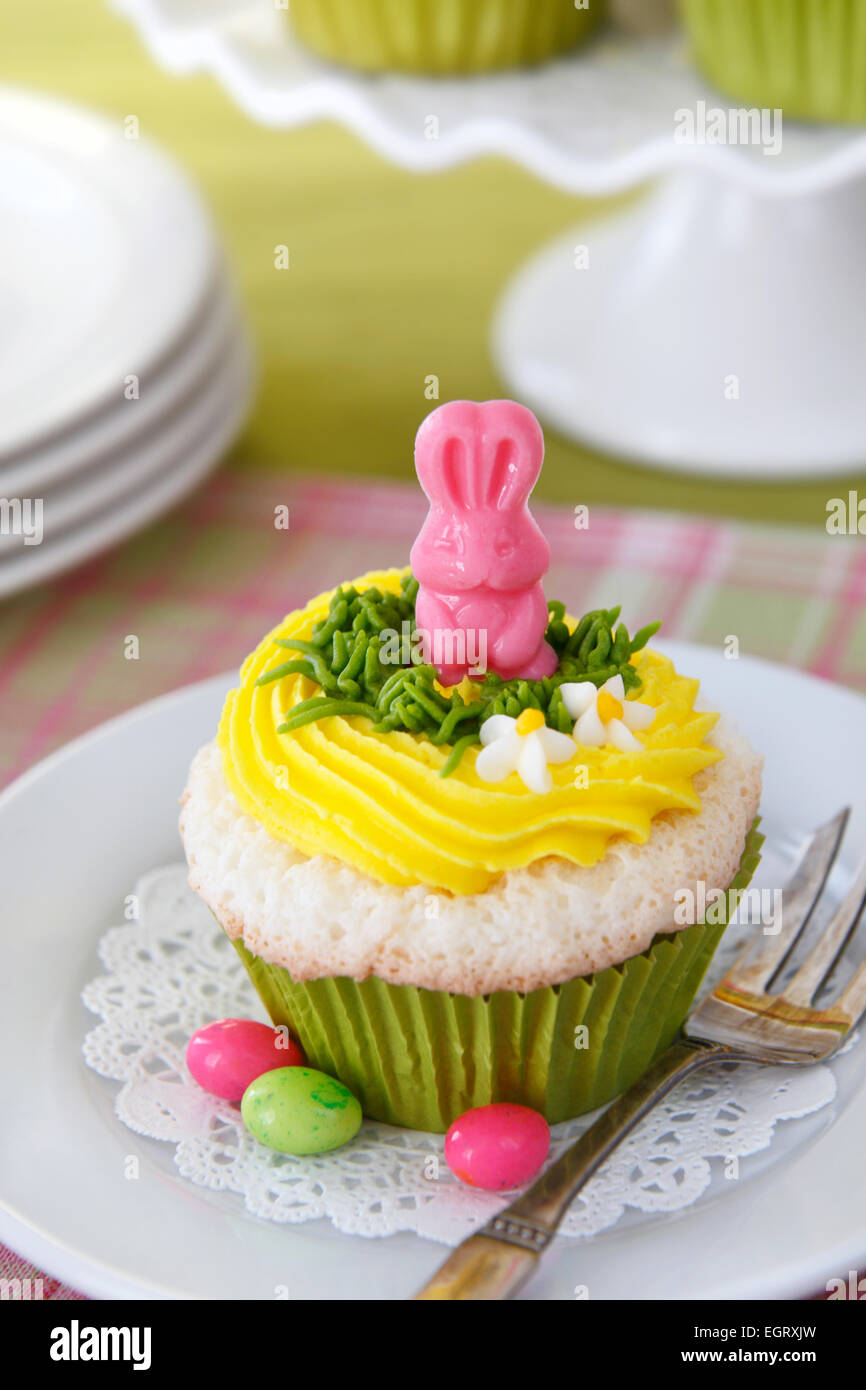 Tortini di pasqua. Angel food cake con glassa alla vaniglia e una caramella bunny. Foto Stock