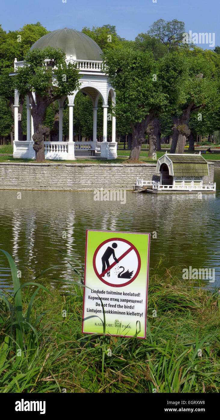 Un gazebo da un laghetto nel Parco di Kadriorg a Tallinn Estonia con un segno in più lingue per vietare l alimentazione dei cigni Foto Stock