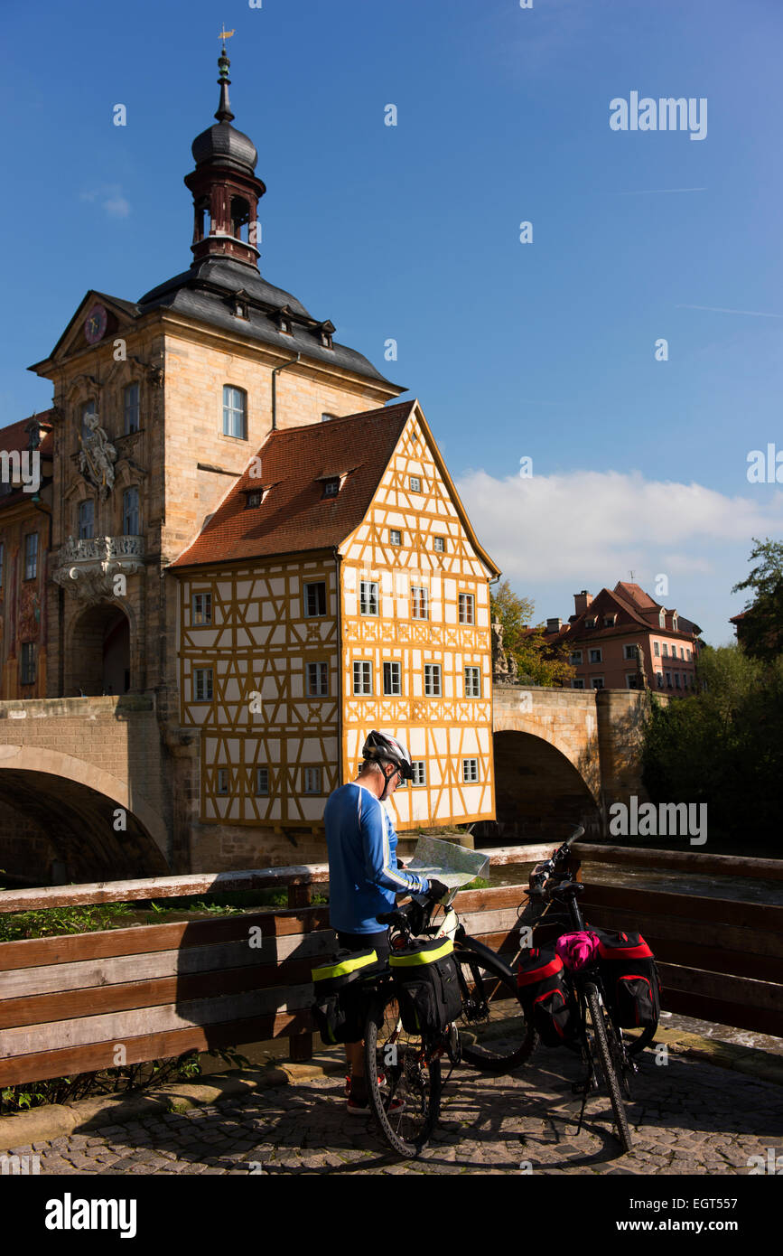 Ciclista controlla la sua mappa nella parte anteriore del centro storico di Bamberg Hall (Altes Rathaus), costruito nel 1462. Foto Stock