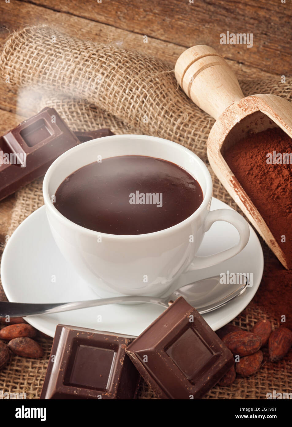 Tazza di cioccolata calda con cacao in polvere, le fave di cacao e pezzi di cioccolato. Foto Stock