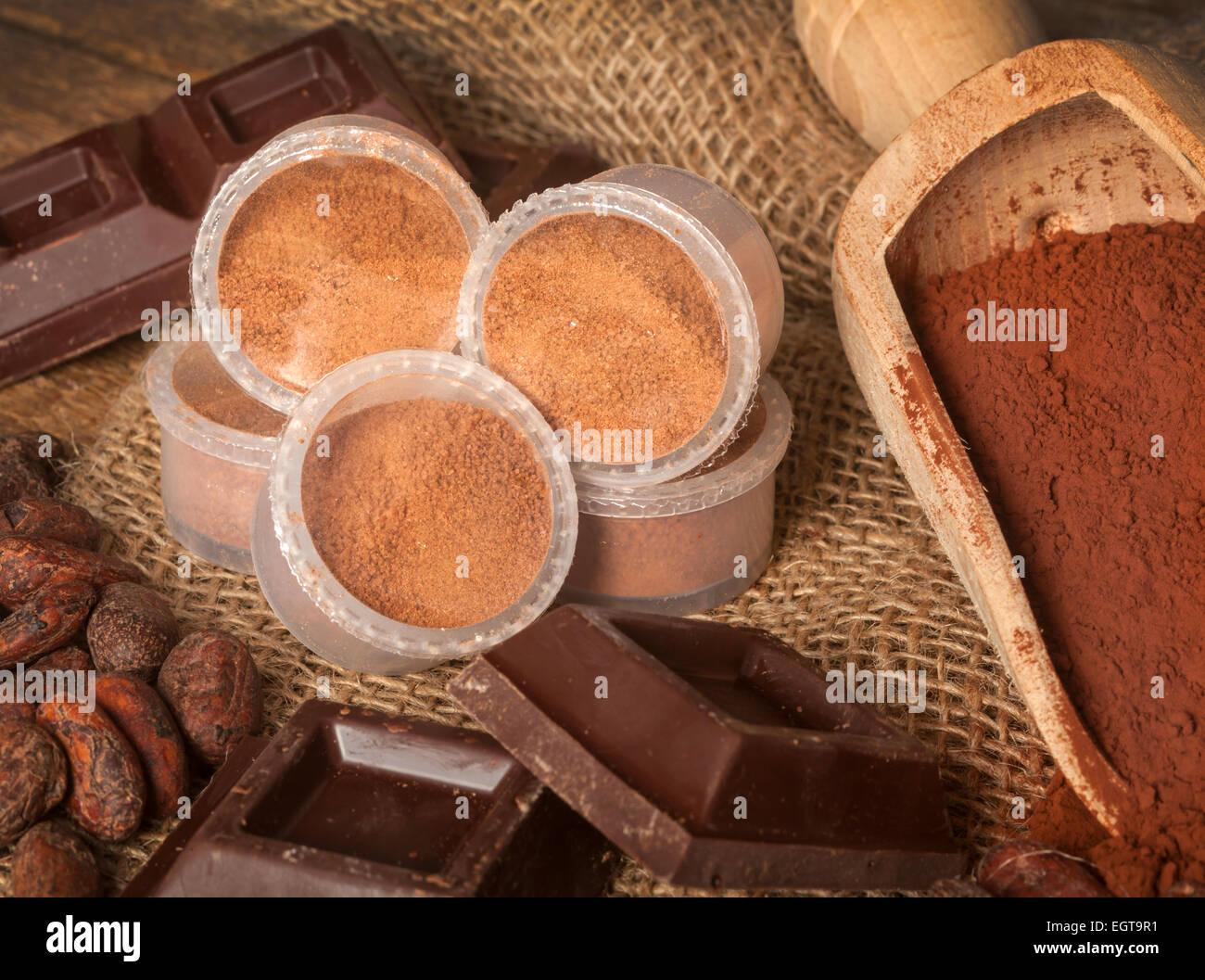 Capsule di cioccolato con il cacao in polvere, le fave di cacao e pezzi di cioccolato. Foto Stock