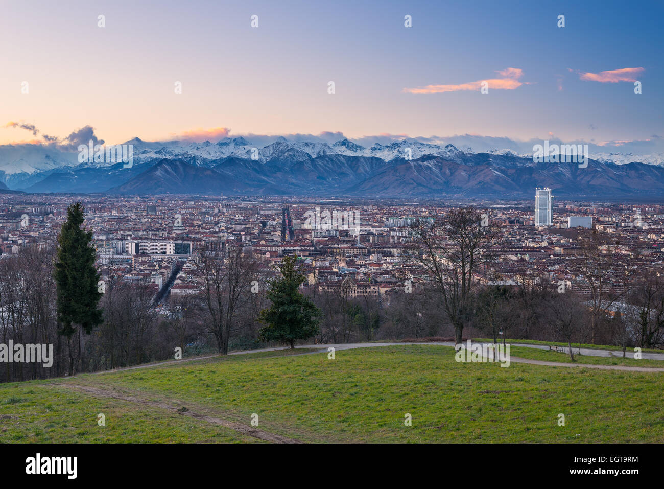 Un punto di vista personale di Torino (Torino), Italia. Paesaggio urbano panoramica da sopra al crepuscolo con scenic nevato montagna impostazione Foto Stock