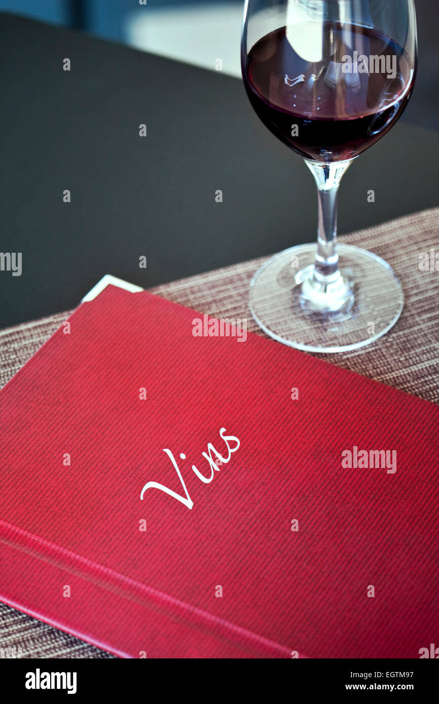 Lista dei vini e un bicchiere di vino rosso in un ristorante francese Foto Stock