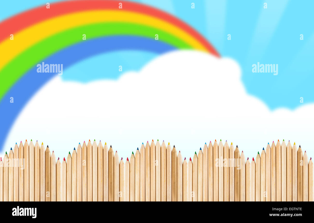 Recinzione fatta con matite di legno sul cielo blu con rainbow Foto Stock