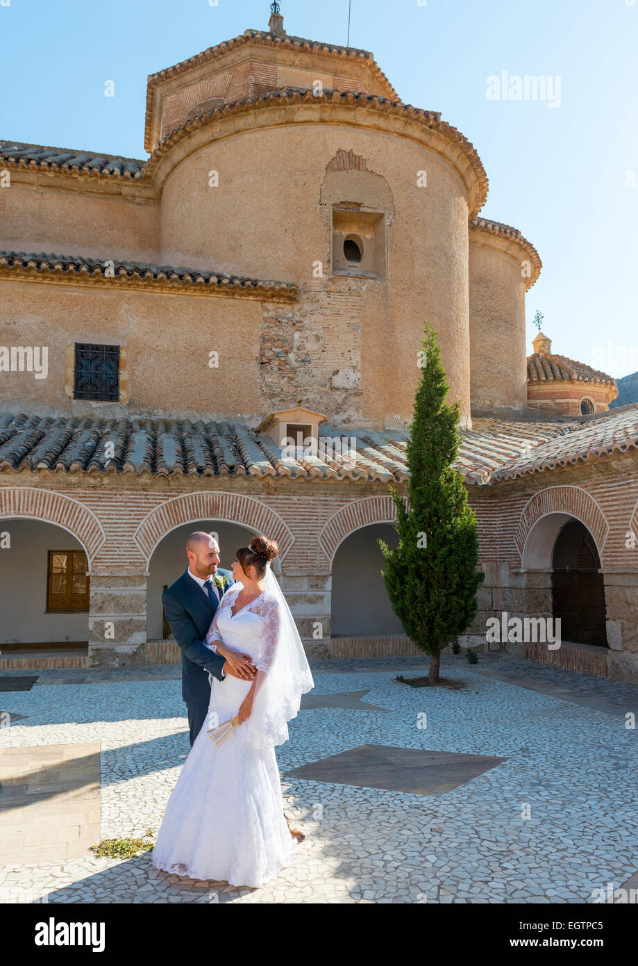 Sposa e lo sposo il giorno delle nozze in una cappella medievale cortile in Spagna Foto Stock