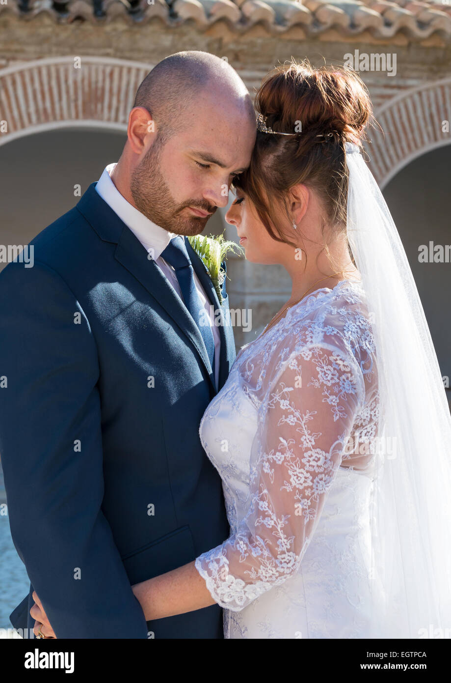 Sposa e lo sposo il giorno delle nozze in una cappella medievale cortile in Spagna Foto Stock