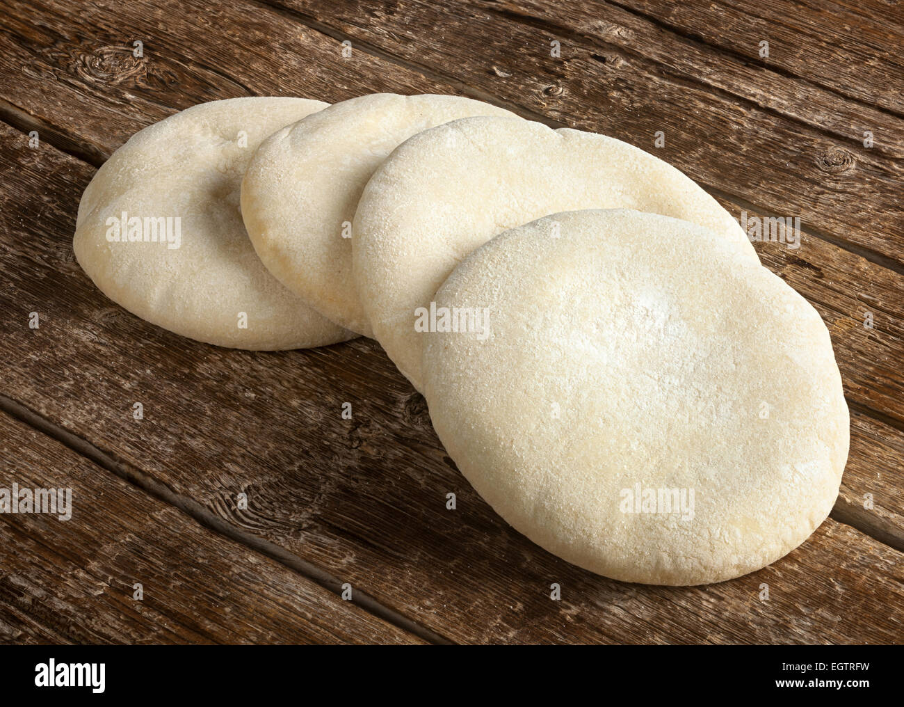 Quattro pagnotte di pane arabo sul tavolo di legno. Foto Stock