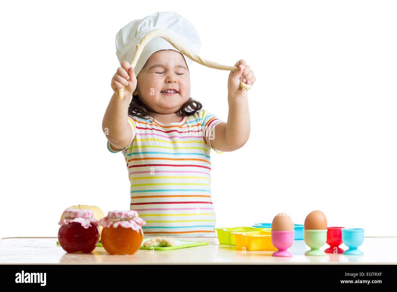 Bambino felice avendo divertimento preparare una torta Foto Stock