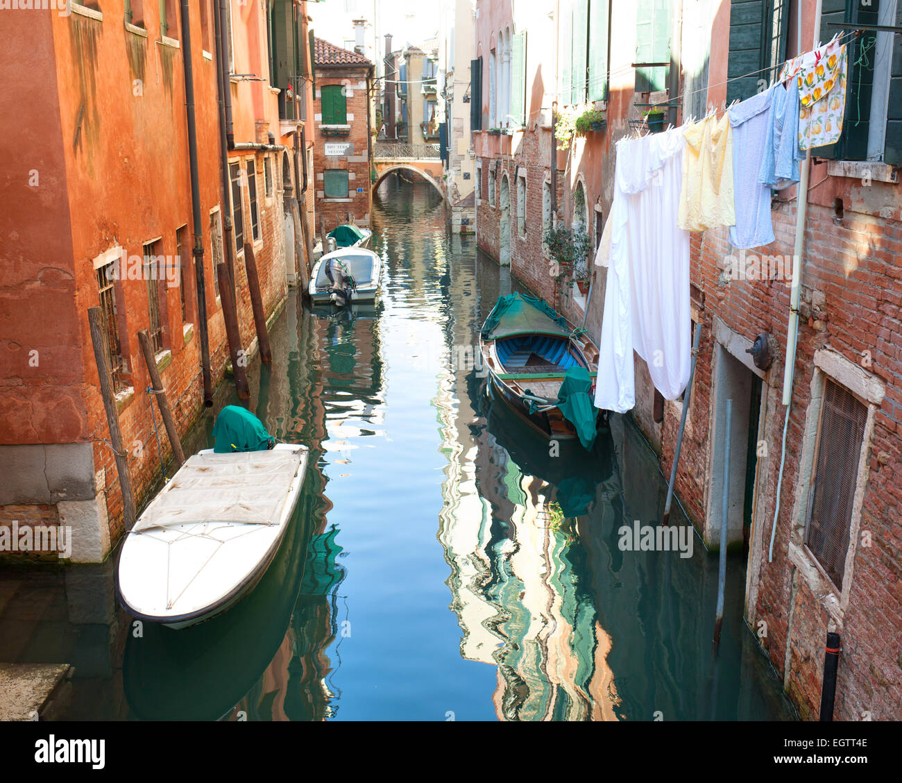 Canale veneziano con barche e vestiti appesi ad asciugare, Venezia, Italia. Foto Stock