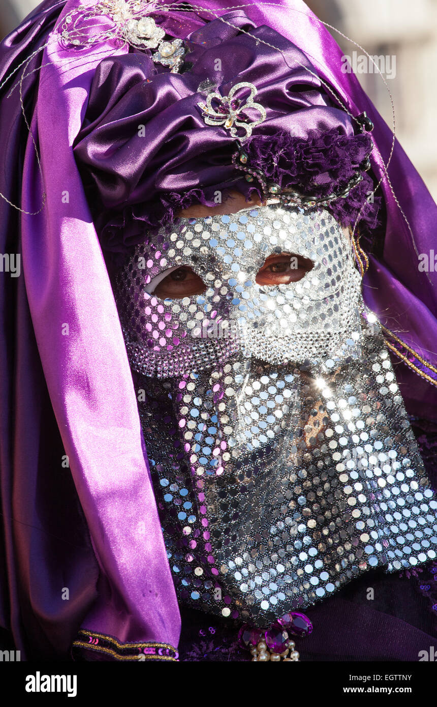 Maschera Veneziana con paiette cromato e il velo di colore viola. Venezia, Italia. Foto Stock