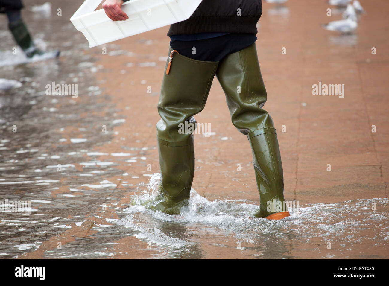 Close Up di gambe con scarponi dovuta all'acqua alta. Questo flusso si verifica quando vi è alta marea a Venezia, Italia. Foto Stock