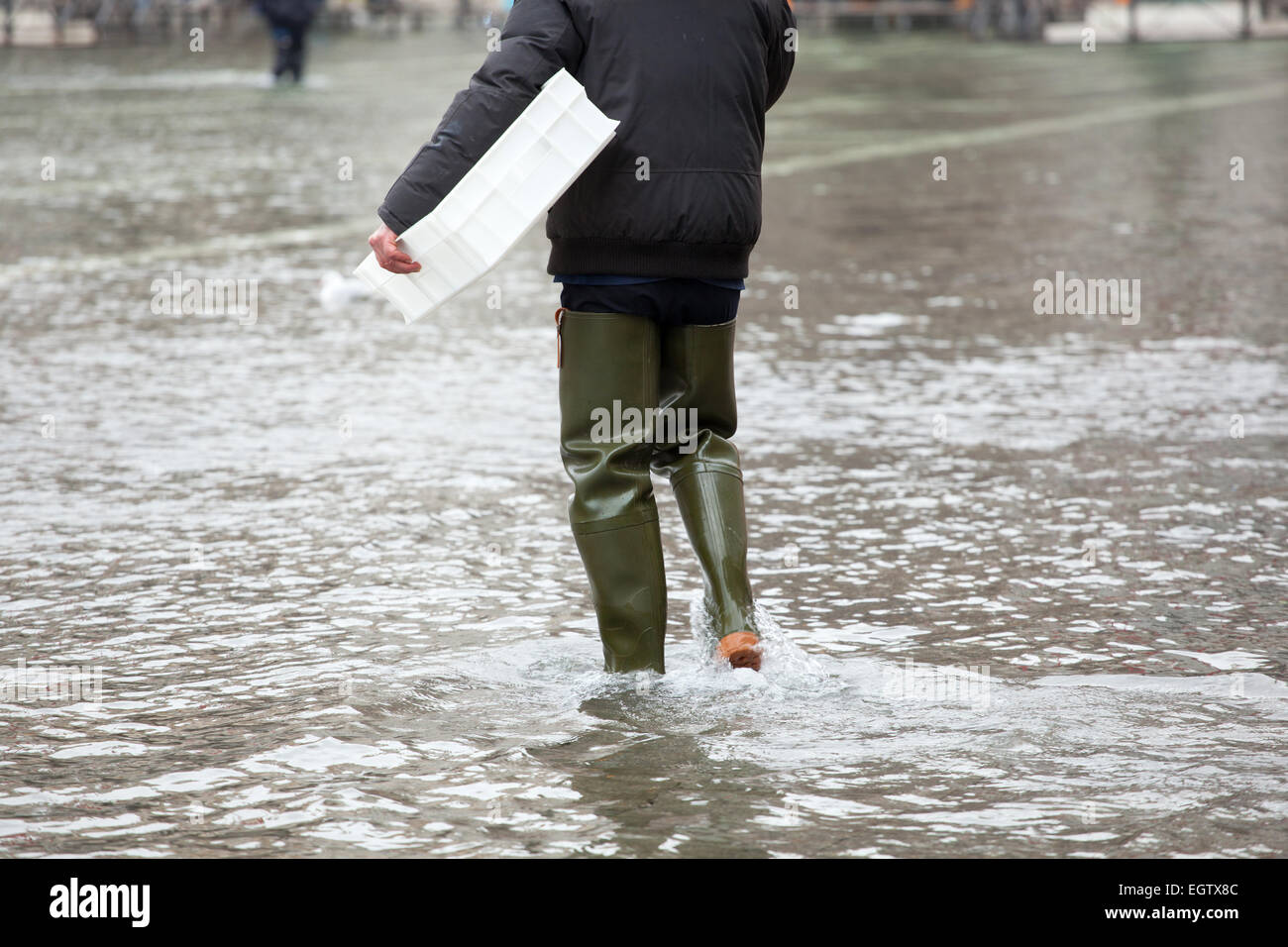 Close Up di gambe con scarponi dovuta all'acqua alta. Questo flusso si verifica quando vi è alta marea a Venezia, Italia. Foto Stock