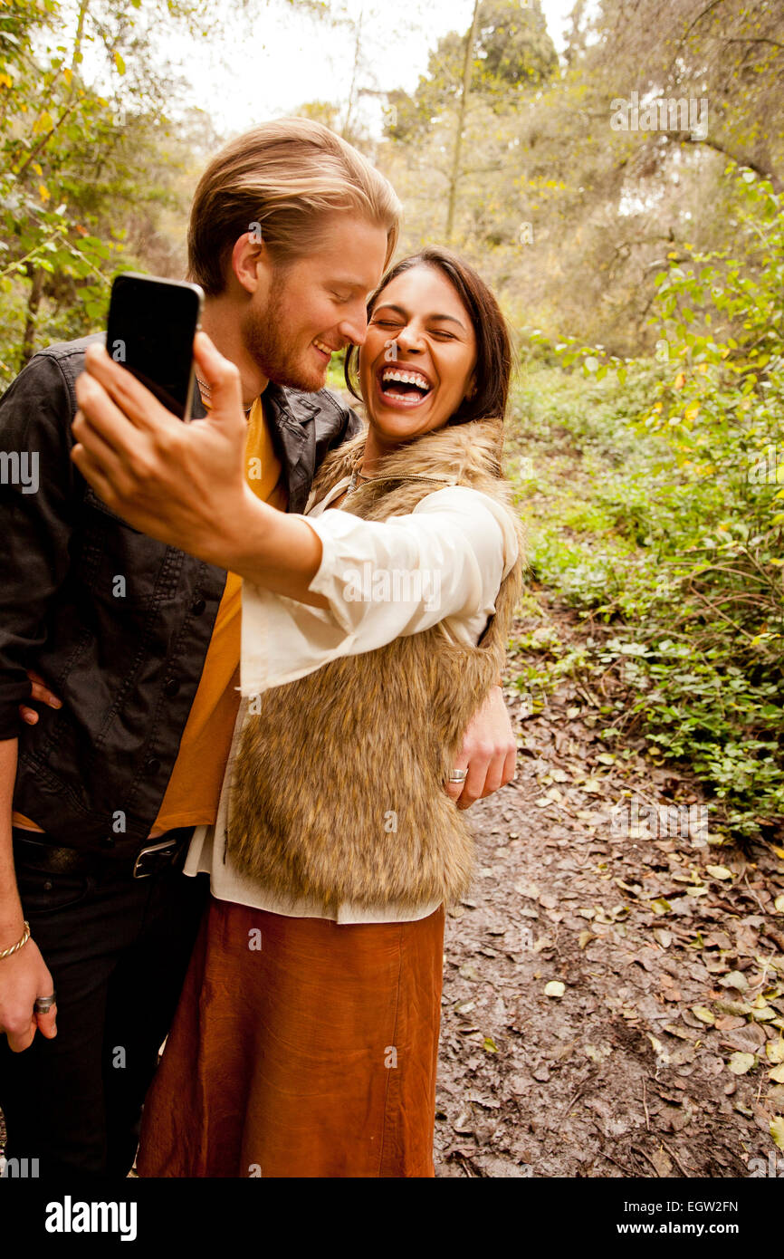 Donna e uomo prendendo un selfie nei boschi. Foto Stock