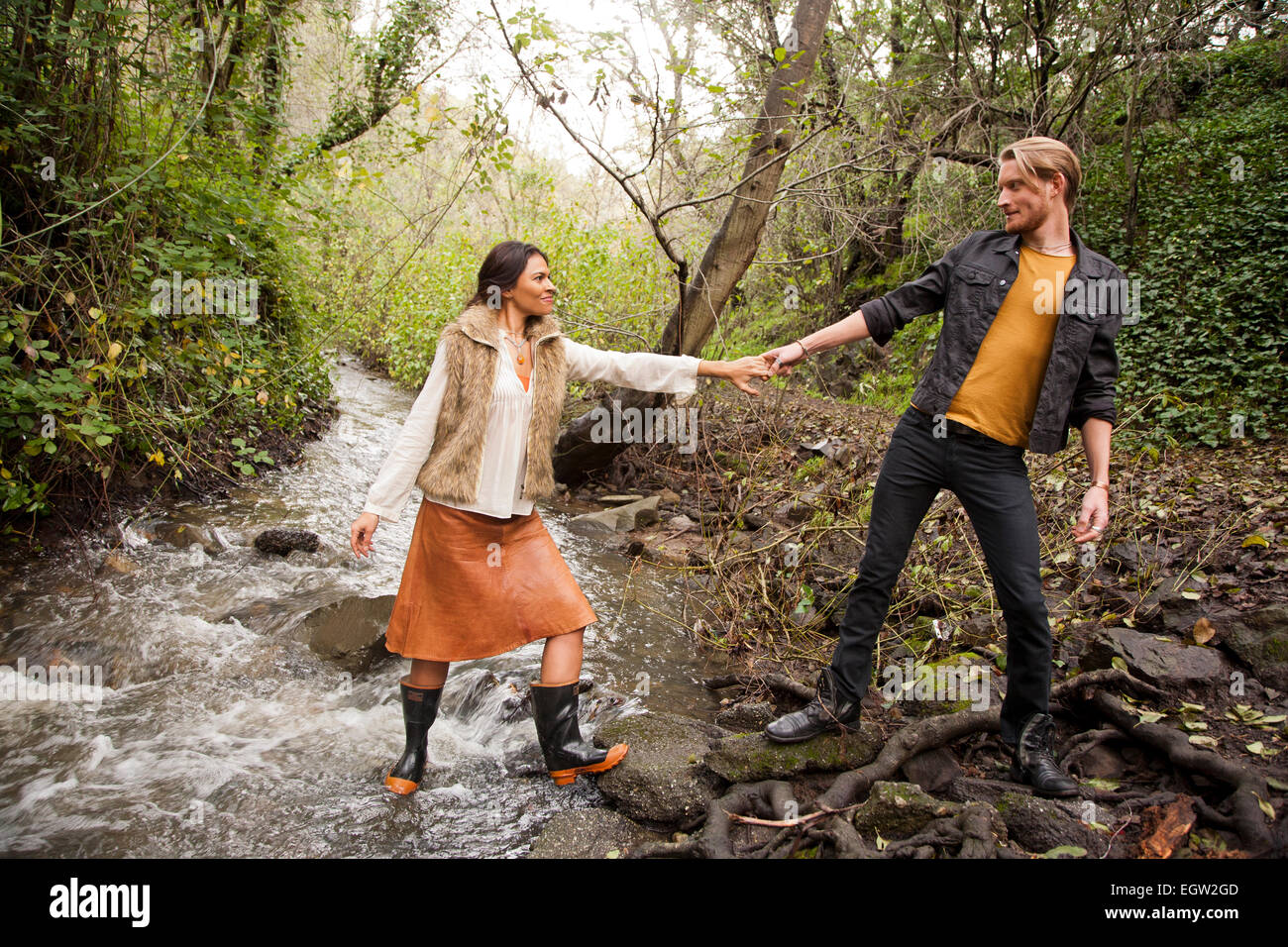 Donna Uomo aiutando attraverso creek. Foto Stock