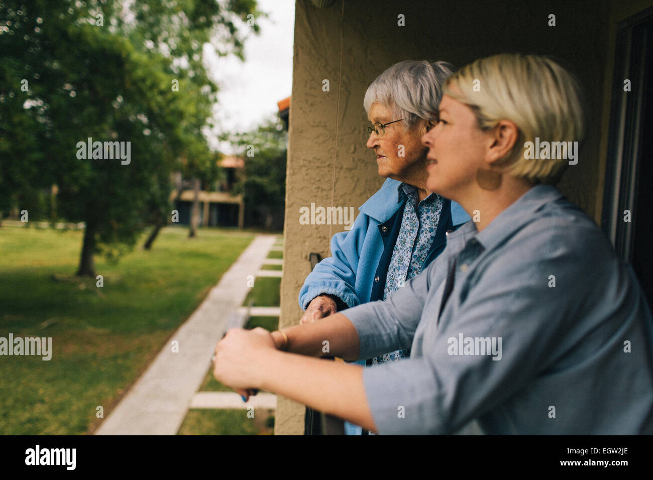 Senior e la donna più giovane donna appoggiata sul portico ringhiera. Foto Stock