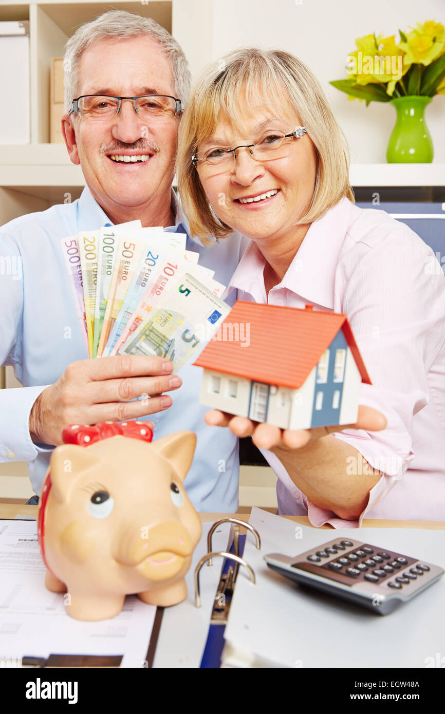 Felice coppia senior risparmiando denaro Euro Bills nel finanziamento della casa Foto Stock