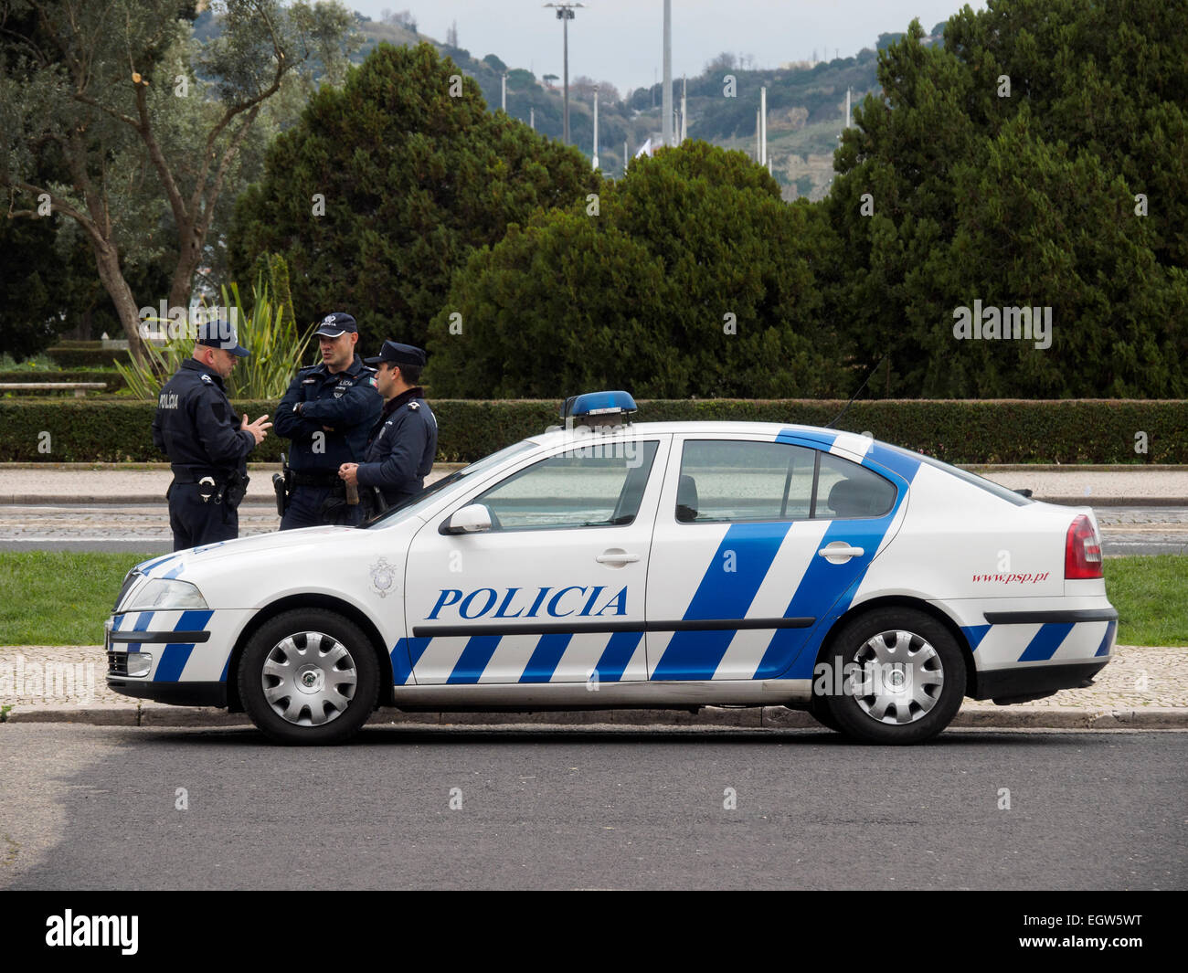 Portoghese di tre funzionari di polizia accanto a una macchina della polizia a Lisbona, Portogallo Foto Stock