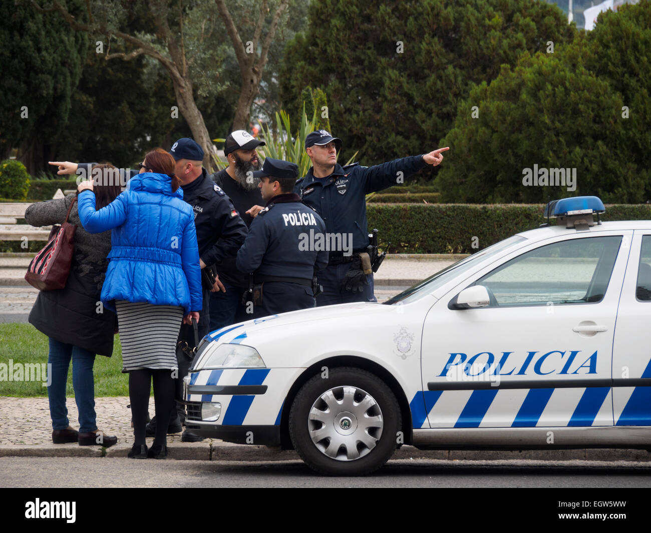 Perduto turisti chiedendo il portoghese di funzionari di polizia per le direzioni accanto a una macchina della polizia a Lisbona, Portogallo Foto Stock