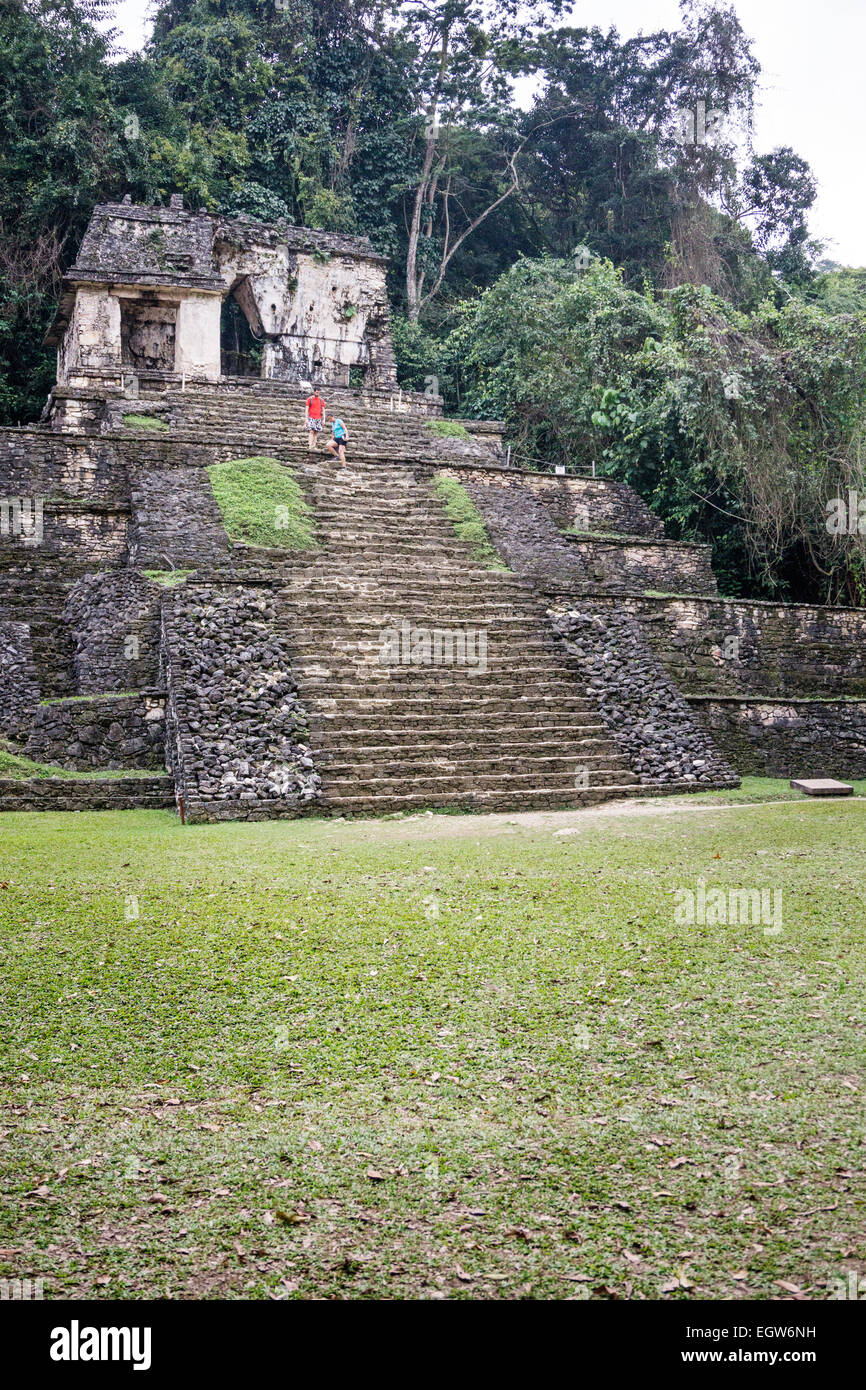 Coppia giovane scendere ripide scale di pietra della piramide a gradini del tempio di base del cranio antica città maya di Palenque Chiapas Foto Stock