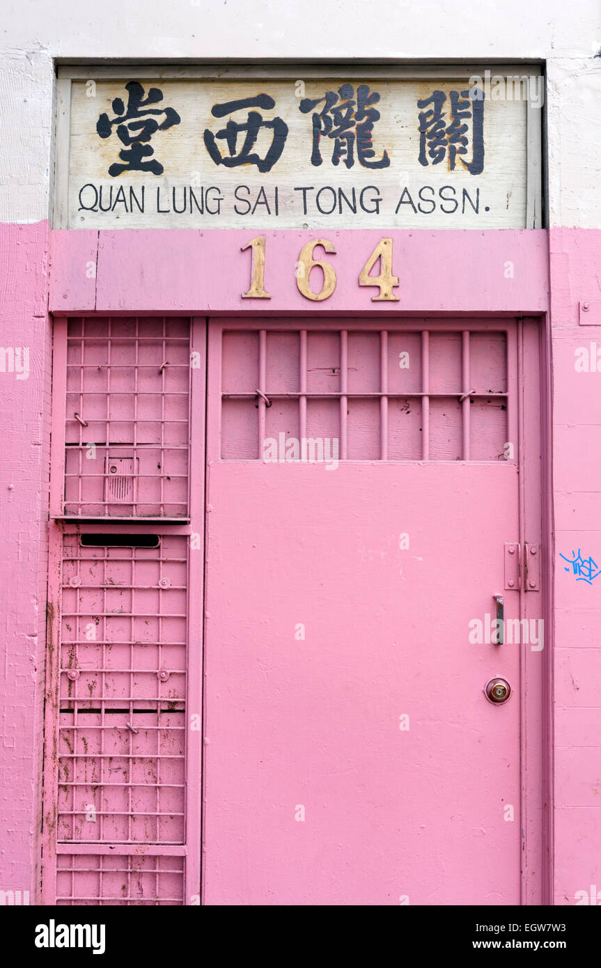 Vecchi rosa rosa porta in legno con caratteri cinesi al di sopra di essa in Chinatown, Vancouver, BC, Canada Foto Stock