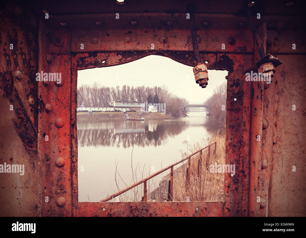 Retrò filtrata grungy industriale lungo il fiume città vista in telaio arrugginito. Foto Stock
