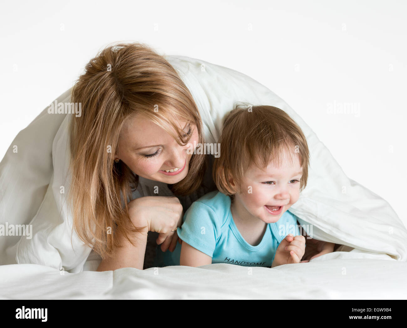 Felice la madre e il bambino che gioca al di sotto di una coperta Foto Stock