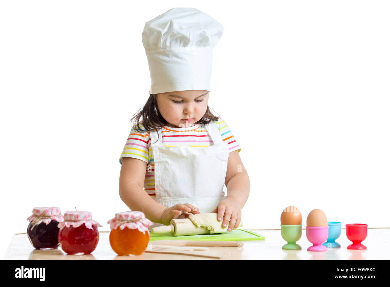 Poco baker kid ragazza nel cappello chef in cucina Foto Stock