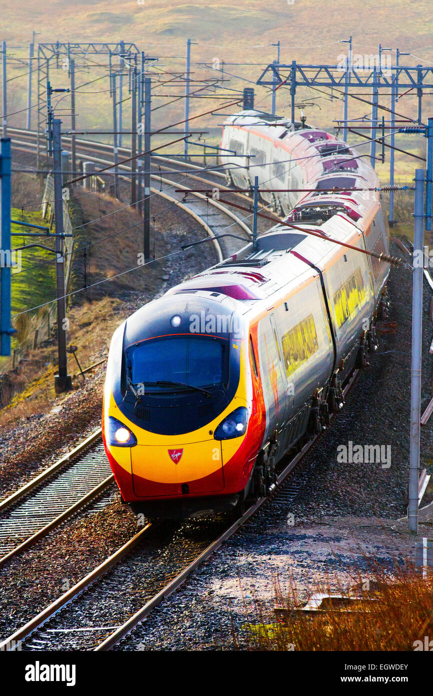 Le linee di alimentazione e portali per elettrico, treni, le vie e i passeggeri di British Railways  Vergine discendente Voyager treno a Shap, West Coast L Foto Stock