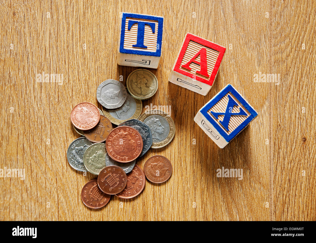 Mattoni di legno blocchi da costruzione giocattolo primo piano che scrive la parola tasse e denaro inglese moneta moneta moneta finanziaria concetto di business Foto Stock